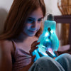 Child holding a glowing blue light bulb-shaped toy with a character inside.